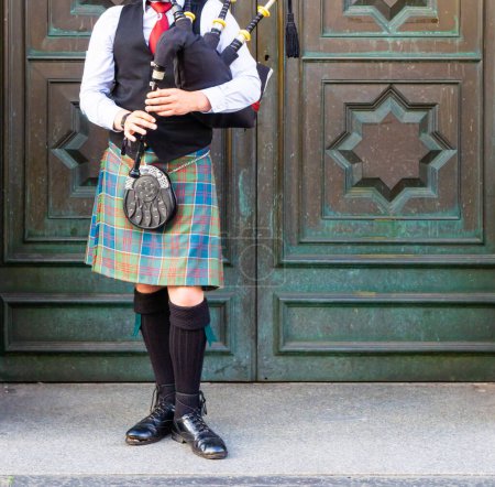 Téléchargez les photos : Vue de face d'un musicien écossais traditionnel jouant de la cornemuse vêtue du kilt de tartan typique lors du festival Fringe à Édimbourg, en Écosse. - en image libre de droit