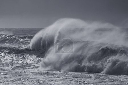 Photo for Winter seascape seeing a big stormy breaking wave with spray in the foreground. Northern portuguese coast. Used infrared filter. - Royalty Free Image