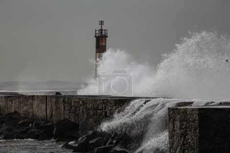 Foto de Salpicadura de onda. Ave muelle de la boca del río y faro en un día de mar agitado, al norte de Portugal. - Imagen libre de derechos