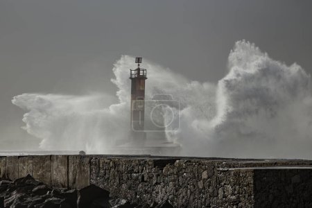 Große Welle plätschert. Ave Flussmündung Pier und Leuchtturm in rauer See Tag, nördlich von Portugal.