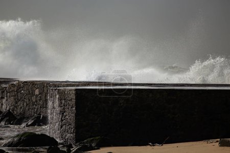 Große Welle plätschert. Ave Flussmündung Pier und Leuchtturm in rauer See Tag, nördlich von Portugal.
