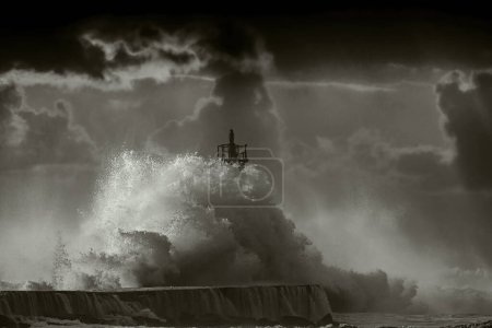 Foto de Gran ola de tormenta contra el faro de Vila do Conde, al norte de Portugal (cielo mejorado), al atardecer - Imagen libre de derechos