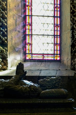 Foto de Lisboa, Portugal - 5 de marzo de 2013: Tumba retroiluminada del poeta Luis de Camoes contra una gran ventana con motivos relacionados con los descubrimientos. Monasterio de Jerónimos en Lisboa, Patrimonio de la Humanidad por la UNESCO
. - Imagen libre de derechos