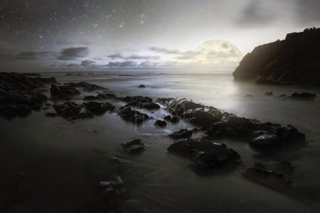 Nocturnal photo composition with moon, clouds, stars, sea and waves