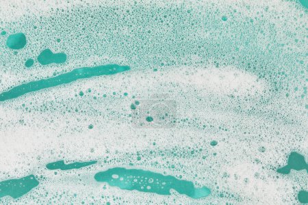 White faomy suds on teal background with copy space