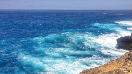 Téléchargez les photos : Une vue sereine depuis une perche rocheuse surplombant l'océan sur l'île de Nusa Penida, Bali, Indonésie, où la beauté de la nature rencontre la mer sans fin - en image libre de droit