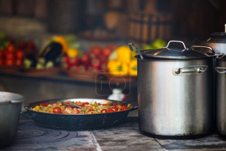 Photo for Cooking street food. Cooking vegetables in a cast iron frying pan outside. Outdoor kitchen - Royalty Free Image
