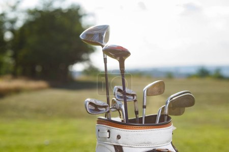 Photo for Golf clubs drivers over green field background. - Royalty Free Image