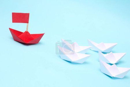Foto de Concepto de liderazgo, barco de papel verde líder entre el blanco sobre fondo blanco - Imagen libre de derechos