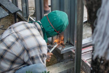 Photo for Worker  welds the steel structure at the construction site. - Royalty Free Image