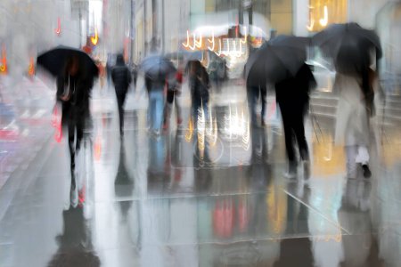 Téléchargez les photos : Les gens d'affaires marchant dans la rue par un mouvement de jour de pluie floue - en image libre de droit