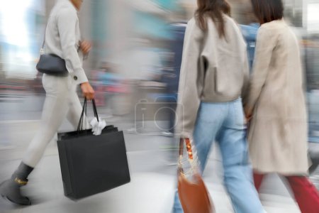 Téléchargez les photos : Gens faisant du shopping dans la ville en mouvement flou - en image libre de droit