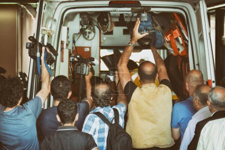 Téléchargez les photos : Caméramans et photographes essayant d'enregistrer ce qui se passe à l'intérieur d'une ambulance - en image libre de droit