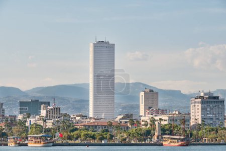 Photo for MERSIN, TURKEY, MAY 2, 2023: Telephoto shot of Mersin Trade Center (Mertim) building; tallest building at old city centre, docked tour boats can be seen at the coastline of Ataturk Park . - Royalty Free Image