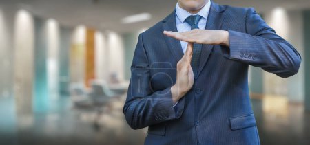 Foto de Businessman with hand gestures shows stop doing work on blurred office background. - Imagen libre de derechos