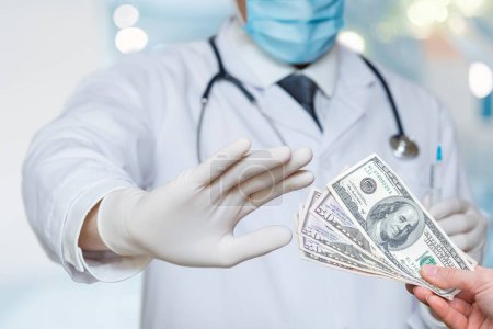 Téléchargez les photos : Le médecin refuse un pot-de-vin d'argent avec un geste de main interdisant. - en image libre de droit