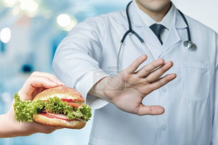 Foto de Concepto de un médico que prohíbe comer comida rápida para la corrección de peso. - Imagen libre de derechos