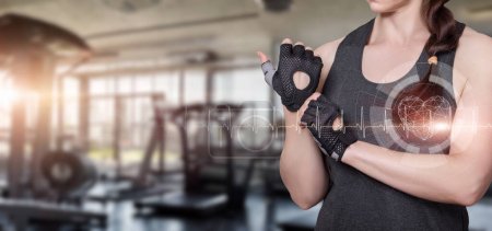 Koncepcja zdrowego treningu wytrzymałościowego na siłowni. Kobieta mierzy puls na tle sali gimnastycznej.