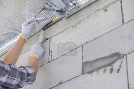 Photo for A qualified contractor applies a vapor barrier between a house and an unheated attic. - Royalty Free Image