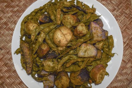 Foto de Umbadiyu un plato especial de invierno Gujarati tradicional, cocinado con verduras de invierno, en una olla de tierra parcialmente subterránea, da aroma ahumado y sabor - Imagen libre de derechos