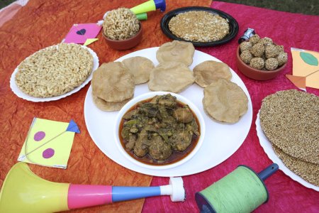 Téléchargez les photos : Makar sankranti nourriture spéciale, Uttarayan festival nourriture Undhiyu et poori avec Til gud patti, chikki, riz soufflé laddoo jaggery mangé pendant le festival de cerf-volant - en image libre de droit