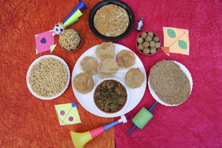 Foto de Makar sankranti comida especial, comida del festival Uttarayan Undhiyu y poori con Til gud patti, chikki, arroz inflado jaggery laddoo comido durante el festival de cometas - Imagen libre de derechos