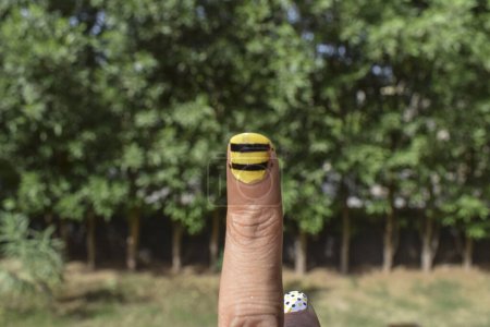Schöne und einfache Nagelkunst aus gelben und schwarzen Streifen auf dem Zeigefinger