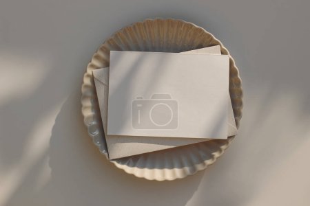 Photo for Summer minimal wedding stationery. Blank horizontal greeting card mockup with beige envelope, invitation. Ceramic scallop dinner plate in sunlight. Table background with shadows overlay, flatlay, top - Royalty Free Image