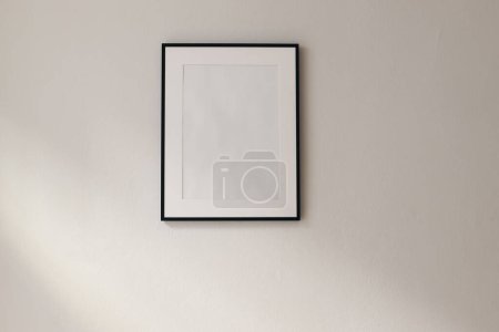 Photo for Artistic mockup template. Black vertical picture frames on beige wall background in sunlight. Poster display at home, minimal Scandinavian design, no people. Elegant apartment concept. Template - Royalty Free Image