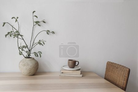 Photo for Spring, Easter breakfast still life. Elegant Scandinavian living room, home office. Cup of coffee, books. Wooden desk, table. Vase with willow tree branches, catkins. Blank wall, copy space. No people - Royalty Free Image