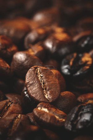 Téléchargez les photos : Vue rapprochée des graines de café brunes sur une surface sombre groupe de grains texturés - en image libre de droit