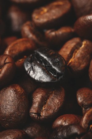 Téléchargez les photos : Vue rapprochée des graines de café brun sur la surface sombre grain de groupe texturé - en image libre de droit