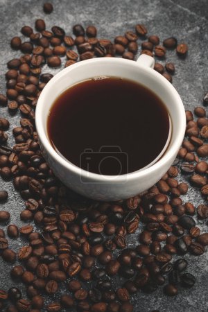 Foto de Vista superior de semillas de café marrón con taza de café de textura de grupo de superficie oscura - Imagen libre de derechos
