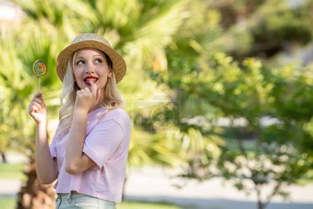Téléchargez les photos : Mignonne fille belle jolie jeune fille blonde en chapeau en été au parc rêvant - en image libre de droit