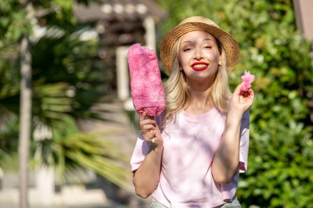 Photo for Cute girl lovely pretty young blonde girl in hat in the summer at the park with sweets - Royalty Free Image