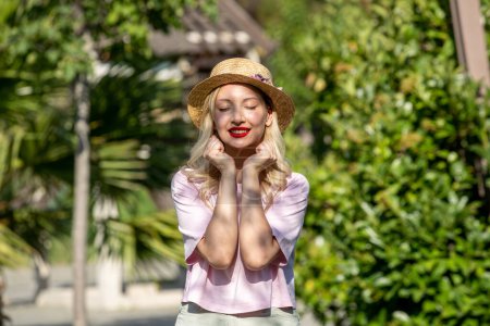 Téléchargez les photos : Fille mignonne jolie jeune fille blonde en chapeau en été au parc excité - en image libre de droit