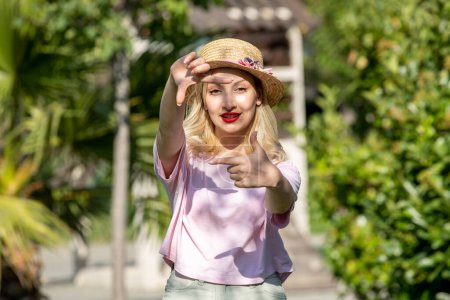 Photo for Cute girl pretty lovely young blonde girl in hat in the summer at the park taking photo - Royalty Free Image
