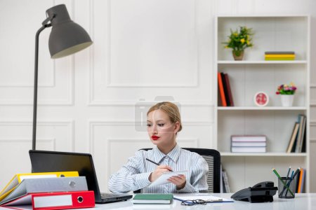 Téléchargez les photos : Secrétaire au bureau belle jeune fille blonde mignonne en chemise avec charge de travail notes d'écriture - en image libre de droit