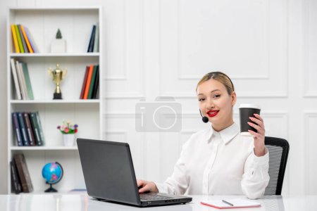 Téléchargez les photos : Service à la clientèle jolie chemise de bureau blonde avec casque et ordinateur tenant tasse en papier - en image libre de droit