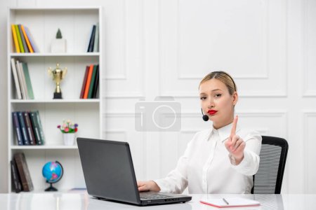 Foto de Servicio al cliente linda chica rubia camisa de oficina con auriculares y ordenador mostrando gesto de parada - Imagen libre de derechos
