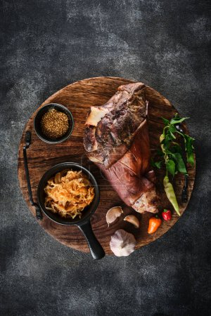 Photo for Smoked pork knuckle with stewed cabbage on a wooden tray - Royalty Free Image