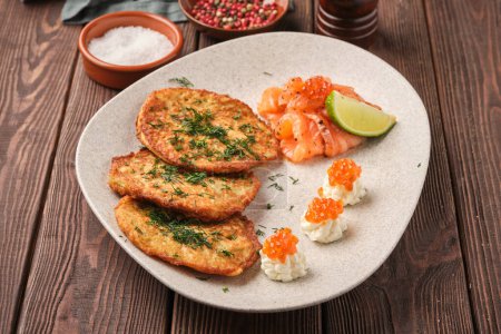 close-up view of golden-brown potato pancakes, freshly cooked and crispy. These traditional dranik pancakes are served with a side of sour cream and garnished with chives. Perfect for breakfast or as a savory snack.