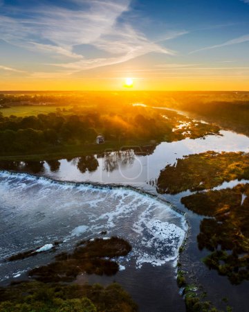 Téléchargez les photos : Vue aérienne de la cascade Venta Rapid, la cascade la plus large d'Europe et long pont en brique, pendant le beau lever du soleil - en image libre de droit