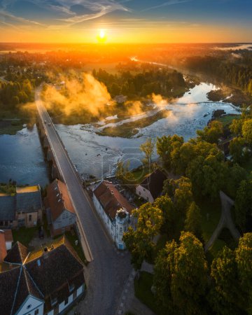 Téléchargez les photos : Vue aérienne de la cascade Venta Rapid, la cascade la plus large d'Europe et long pont en brique, pendant le beau lever du soleil - en image libre de droit