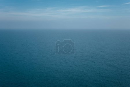 The front view of the sea with morning sky and fuzzy horizon. The ocean deep indigo color in daylight. Feeling calm, cool and relaxing