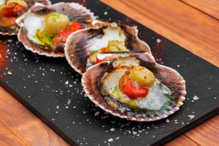 Cooked scallops on blackstone slate plate with species. Variety of mediterranean seafood