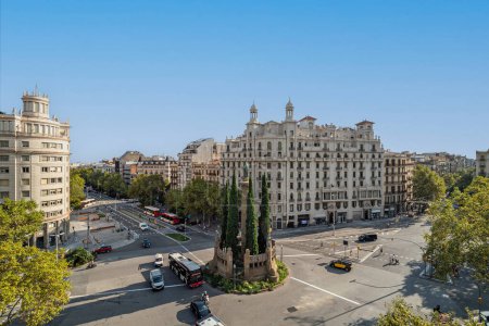 Verdaguer square in Barcelona, Spain. Crossroad with traffic and monument in center of the city on sunny day.
