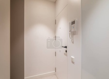 Photo for Entrance hall area in modern refurbished apartment. White walls and door with intercom system - Royalty Free Image