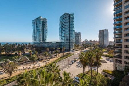 Modern buildings and sunny park in coastal area with sea view, distict Diagonal mar in Barcelona, Spain.
