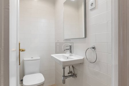 Kompaktes und sauberes Badezimmer mit weißen U-Bahn-Fliesen, modernem Waschbecken und silbernen Armaturen.